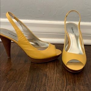 Yellow sling back peep toe pumps.